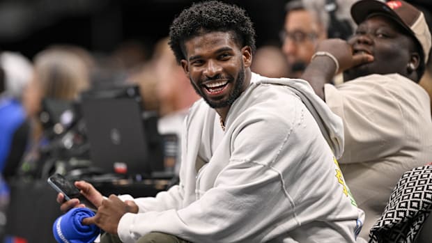 Colorado Buffaloes quarterback Shedeur Sanders laughs as he watches the game between the Dallas Mavericks and Denver Nuggets