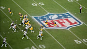 Packers quarterback Jordan Love hands off to running back Josh Jacobs in the first quarter.