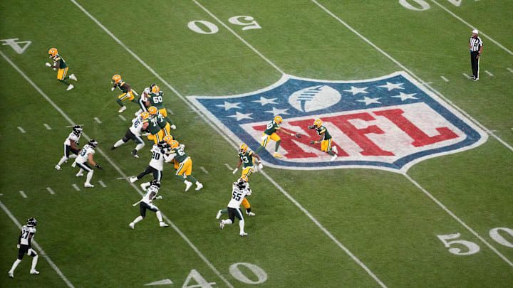 Packers quarterback Jordan Love hands off to running back Josh Jacobs in the first quarter.