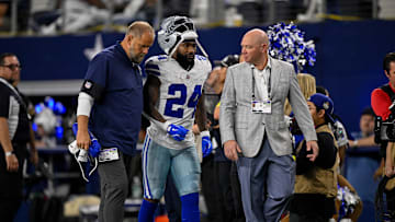 Sep 28, 2025; Arlington, Texas, USA; Dallas Cowboys running back Miles Sanders (24) walks off the field with team staff during the game between the Dallas Cowboys and the Green Bay Packers at AT&T Stadium. Mandatory Credit: Jerome Miron-Imagn Images