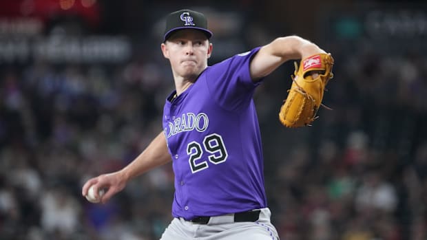 Gordon getting ready to release a white baseball in a solid purple jersey with black lettering and a black ha