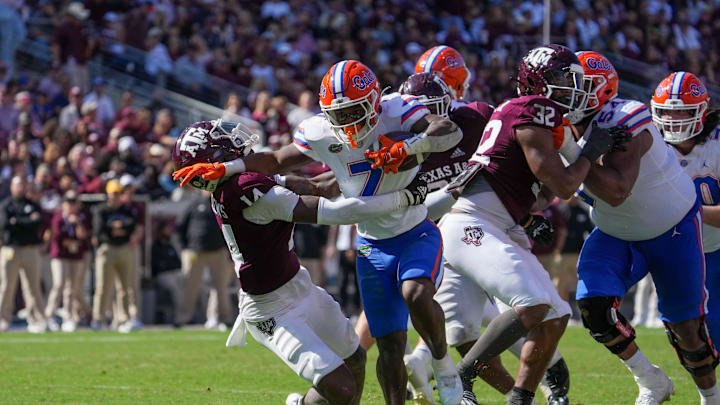 Nov 5, 2022; College Station, Texas, USA; Florida Gators running back Trevor Etienne (7) pushes Texas A&M Aggies defensive back Jacoby Mathews (14) back in the second half at Kyle Field. Mandatory Credit: Daniel Dunn-Imagn Images