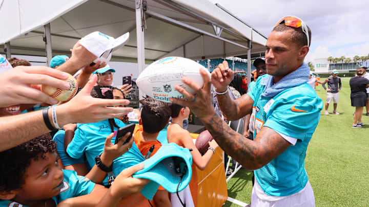 Jul 28, 2024; Miami Gardens, FL, USA; Miami Dolphins safety Jordan Poyer (21) signs autographs to fans during training camp at Baptist Health Training Complex. 