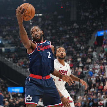 Nov 3, 2025; Inglewood, California, USA; LA Clippers forward Kawhi Leonard (2) reaches for the ball against Miami Heat guard Norman Powell (24) in the first half at Intuit Dome. Mandatory Credit: Kirby Lee-Imagn Images
