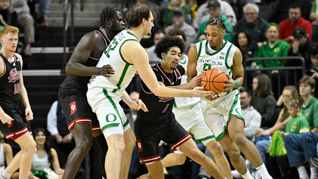 Mar 4, 2025; Eugene, Oregon, USA; Oregon Ducks center Nate Bittle (32) hands the ball off to Oregon Ducks guard Keeshawn Bart