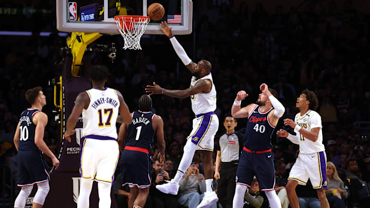 Mar 2, 2025; Los Angeles, California, USA; Los Angeles Lakers forward LeBron James (23) shoots against LA Clippers guard James Harden (1) and center Ivica Zubac (40) during the third quarter at Crypto.com Arena.
