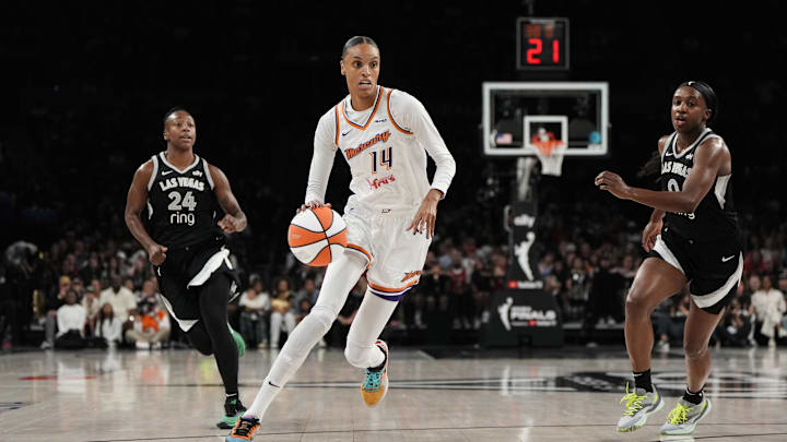 Oct 5, 2025; Las Vegas, Nevada, USA; Phoenix Mercury forward DeWanna Bonner (14) dribbles the ball against Las Vegas Aces guards Jewell Loyd (24) and Jackie Young (0) during the first quarter of game two of the 2025 WNBA Finals at Michelob Ultra Arena. Mandatory Credit: Lucas Peltier-Imagn Images