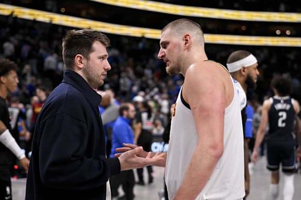 Dallas Mavericks guard Luka Doncic (left) talks with Denver Nuggets center Nikola Jokic (right)