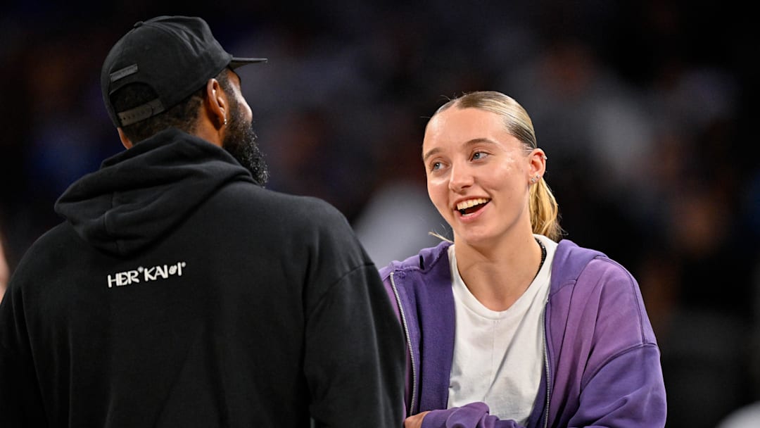 Oct 6, 2025; Fort Worth, Texas, USA; Dallas Mavericks guard Kyrie Irving (left) talks with Dallas Wings guard Paige Bueckers (right) during the second half of the game between the Mavericks and the Oklahoma City Thunder at Dickie's Arena. Mandatory Credit: Jerome Miron-Imagn Images