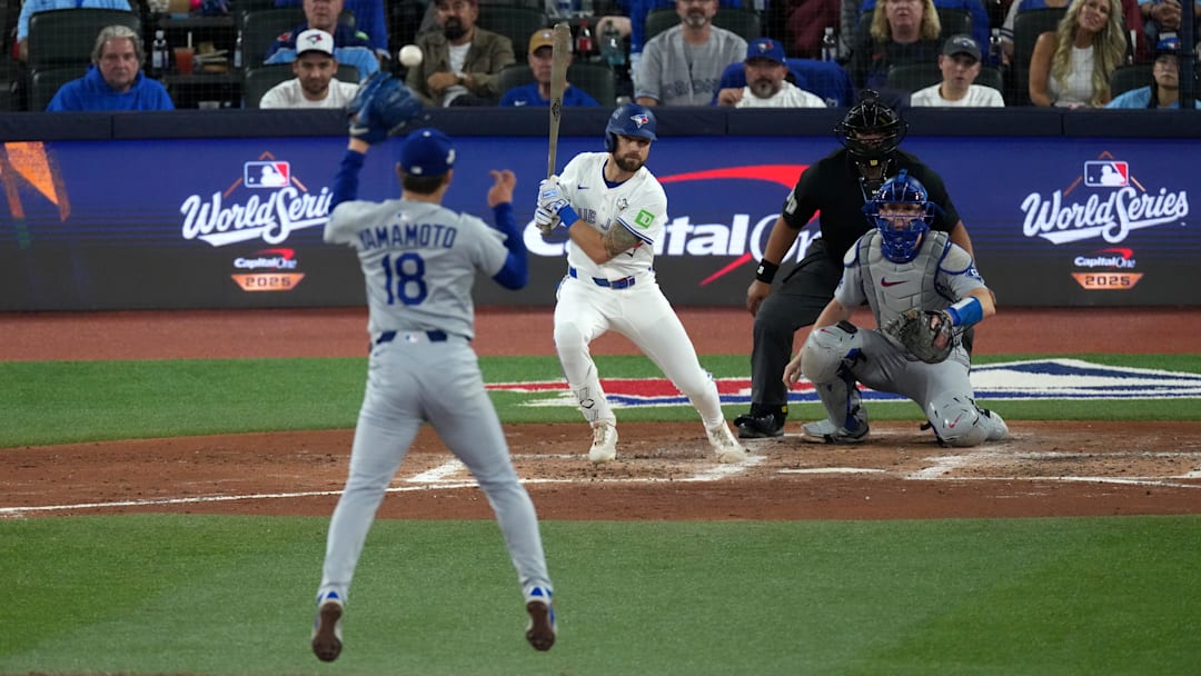 Oct 25, 2025; Toronto, Ontario, CAN;  Los Angeles Dodgers pitcher Yoshinobu Yamamoto (18) makes a catch against Toronto Blue Jays right fielder Nathan Lukes (38) in the fifth inning during game two of the 2025 MLB World Series at Rogers Centre.