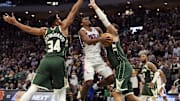 Oct 26, 2023; Milwaukee, Wisconsin, USA;  Philadelphia 76ers guard Tyrese Maxey (0) drives for the basket between Milwaukee Bucks forward Giannis Antetokounmpo (34) ad center Brook Lopez (11) during the fourth quarter at Fiserv Forum. Mandatory Credit: Jeff Hanisch-Imagn Images