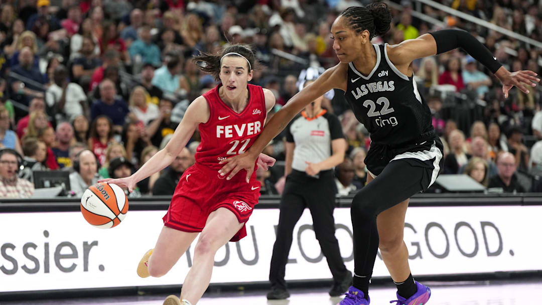 Jun 22, 2025; Las Vegas, Nevada, USA; Indiana Fever guard Caitlin Clark (22) dribbles the ball against Las Vegas Aces center A'ja Wilson (22) during the second half of a WNBA basketball game at T-Mobile Arena. Mandatory Credit: Lucas Peltier-Imagn Images