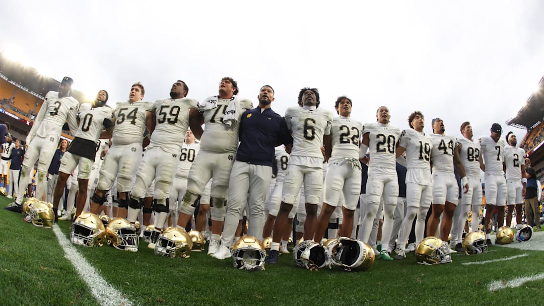 Nov 15, 2025; Pittsburgh, Pennsylvania, USA; Notre Dame Fighting Irish head coach Marcus Freeman (middle) joins his players in singing the victory song after defeating the Pittsburgh Panthers at Acrisure Stadium. Mandatory Credit: Charles LeClaire-Imagn Images Nov 15, 2025; Pittsburgh, Pennsylvania, USA; Notre Dame Fighting Irish head coach Marcus Freeman (middle) joins his players in singing the victory song after defeating the Pittsburgh Panthers at Acrisure Stadium. Mandatory Credit: Charles LeClaire-Imagn Images