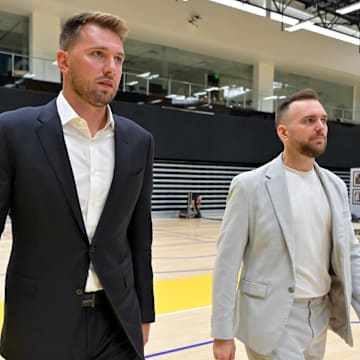 Aug 2, 2025; El Segundo, CA, USA; Los Angeles Lakers Luka Doncic (77) walks with team communications director Mitch Heckart following a press conference announcing the signing of a 3-year, $165 million contract extension at UCLA Health Training Center. Mandatory Credit: Jayne Kamin-Oncea-Imagn Images