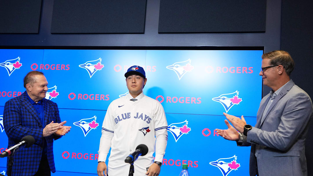 Jan 6, 2026; Toronto, Ontario, Canada; Toronto Blue Jays Kazuma Okamoto is presented to the media with jersey and a baseball cap during the press conference room at Rogers Centre. Mandatory Credit: Nick Turchiaro-Imagn Images