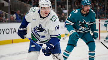 Nov 2, 2024; San Jose, California, USA; Vancouver Canucks left wing Jake DeBrusk (74) skates against San Jose Sharks defenseman Jan Rutta (84) during the first period at SAP Center at San Jose. Mandatory Credit: Robert Edwards-Imagn Images