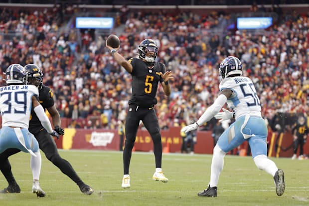 Washington Commanders quarterback Jayden Daniels (5) throws a touchdown pass over Tennessee Titans linebacker Kenneth Murray 