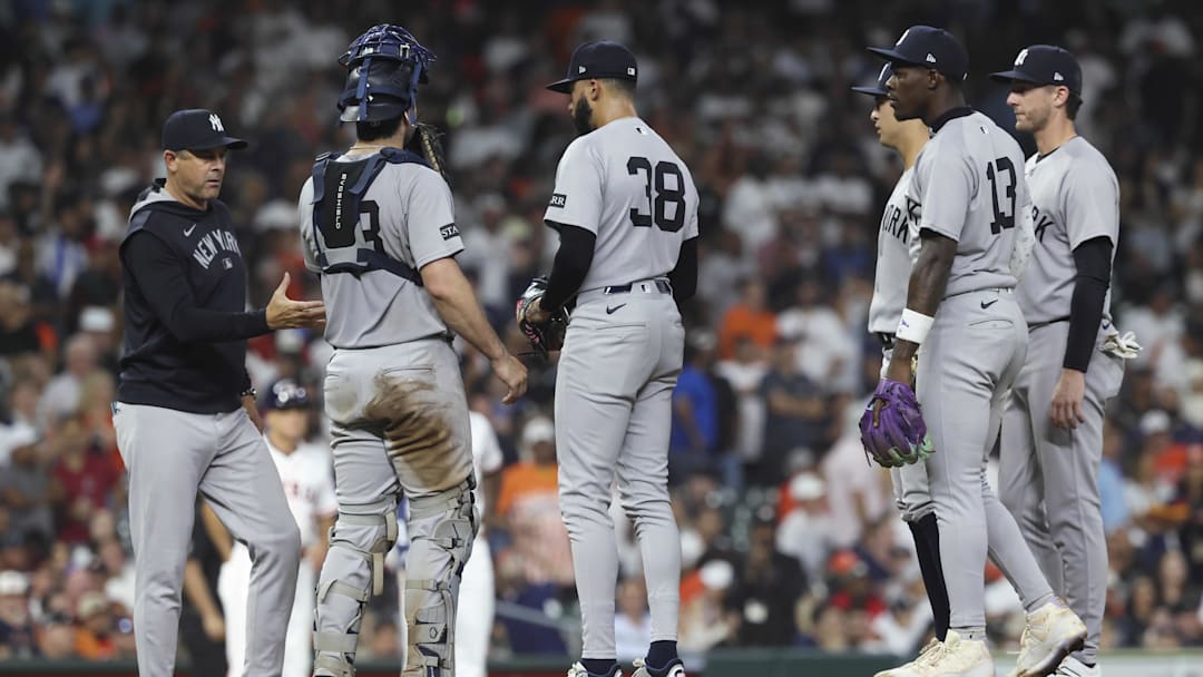 Sep 3, 2025; Houston, Texas, USA; New York Yankees relief pitcher Devin Williams (38) gives the ball to manager Aaron Boone during a pitching change in the eighth inning against the Houston Astros at Daikin Park. Mandatory Credit: Troy Taormina-Imagn Images