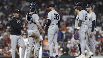 Sep 3, 2025; Houston, Texas, USA; New York Yankees relief pitcher Devin Williams (38) gives the ball to manager Aaron Boone during a pitching change in the eighth inning against the Houston Astros at Daikin Park. Mandatory Credit: Troy Taormina-Imagn Images