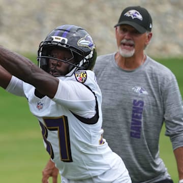 Jul 24, 2025; Owings Mills, MD, USA; Baltimore Ravens coach Chuck Pagano and cornerback Robert Longerbeam (37) work on drills during training camp at the Under Armour Performance Center. Mandatory Credit: Mitch Stringer-Imagn Images