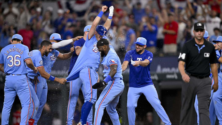 Aug 18, 2024; Arlington, Texas, USA; Texas Rangers left fielder Wyatt Langford (36) and second baseman Marcus Semien (2) and designated hitter Josh Jung (6) and right fielder Adolis Garcia (53) and starting pitcher Nathan Eovaldi (17) celebrate after the Rangers defeat the Minnesota Twins in extra innings at Globe Life Field. Mandatory Credit: Jerome Miron-USA TODAY Sports