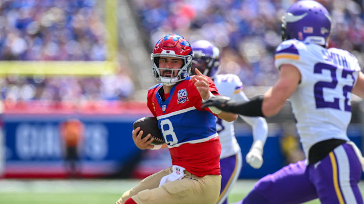 Sep 8, 2024; East Rutherford, New Jersey, USA; New York Giants quarterback Daniel Jones (8) carries the ball while being defended by Minnesota Vikings safety Harrison Smith (22) during the first half at MetLife Stadium.  