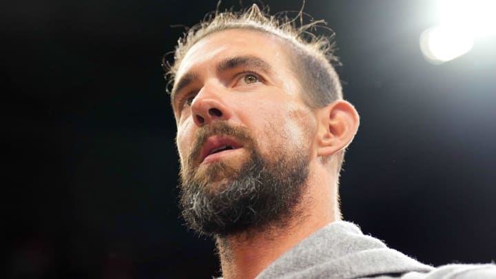 Olympic gold medal swimmer Michael Phelps looks on during an NBA game.