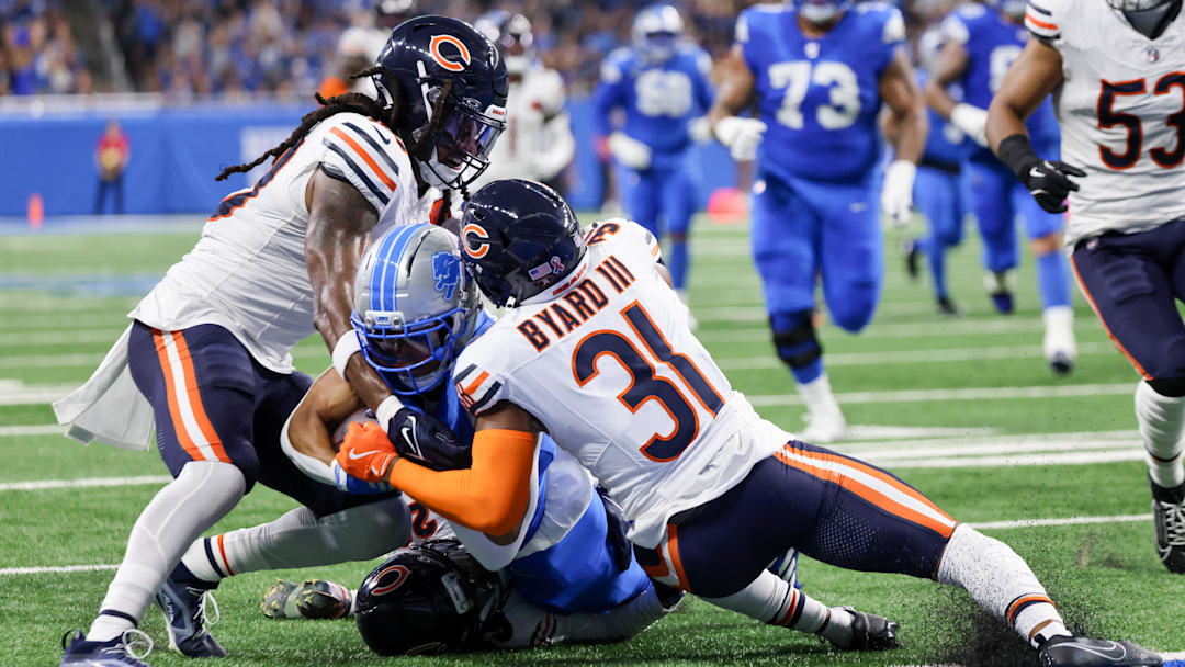 Sep 14, 2025; Detroit, Michigan, USA; Chicago Bears linebacker Tremaine Edmunds (49), cornerback Tyrique Stevenson (29) and safety Kevin Byard III (31) tackle Detroit Lions wide receiver Amon-Ra St. Brown (14) during the first quarter at Ford Field. Mandatory Credit: David Reginek-Imagn Images