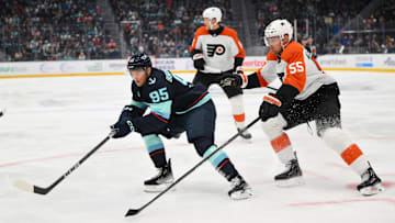 Oct 17, 2024; Seattle, Washington, USA; Seattle Kraken left wing Andre Burakovsky (95) and Philadelphia Flyers defenseman Rasmus Ristolainen (55) play the puck during the first period at Climate Pledge Arena.