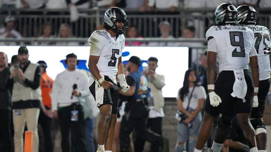 Sep 27, 2025; University Park, Pennsylvania, USA; Oregon Ducks quarterback Dante Moore (5) reacts after a touchdown with tight end Jamari Johnson (9) and offensive lineman Emmanuel Pregnon (75) at Beaver Stadium. Mandatory Credit: James Lang-Imagn Images