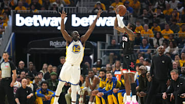 Houston Rockets guard Jalen Green (4) shoots against Golden State Warriors forward Draymond Green.