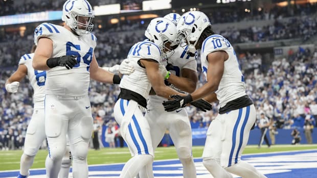 Colts players (all-white uniforms) celebrate after Josh Downs scores a touchdown.