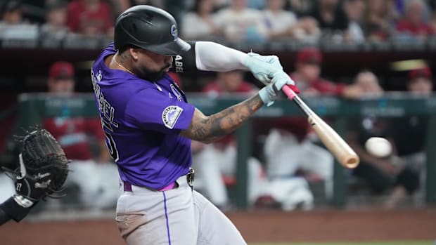 Colorado Rockies shortstop Warming Bernabel swings bat in purple jersey and black helmet