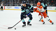 Oct 9, 2025; Seattle, Washington, USA; Seattle Kraken right wing Jordan Eberle (7) plays the puck while defended by Anaheim Ducks right wing Sam Colangelo (12) during the third period at Climate Pledge Arena. Mandatory Credit: Steven Bisig-Imagn Images