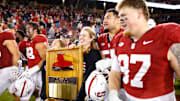 Nov 22, 2025; Stanford, California, USA; Stanford Cardinal players take possession of the axe after the game against the California Golden Bears at Stanford Stadium. Mandatory Credit: Sergio Estrada-Imagn Images