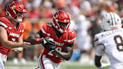 Sep 20, 2025; Louisville, Kentucky, USA;  Louisville Cardinals running back Keyjuan Brown (22) runs the ball against Bowling Green Falcons cornerback Jalen McClendon (8) during the first half at L&N Federal Credit Union Stadium. Mandatory Credit: Jamie Rhodes-Imagn Images
