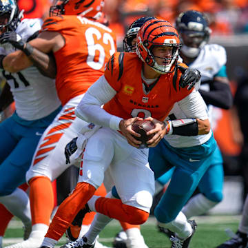 Cincinnati Bengals quarterback Joe Burrow (9) is wrapped up as he scrambles in the first quarter of the NFL Week 2 game between the Cincinnati Bengals and the Jacksonville Jaguars at Paycor Stadium in downtown Cincinnati on Sunday, Sept. 14, 2025. The Jaguars led 17-10 at halftime.
