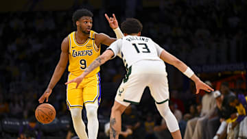 Mar 20, 2025; Los Angeles, California, USA; Los Angeles Lakers guard Bronny James (9) looks to pass against Milwaukee Bucks guard Ryan Rollins (13) during the second half at Crypto.com Arena. Mandatory Credit: Jonathan Hui-Imagn Images