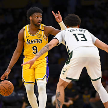 Mar 20, 2025; Los Angeles, California, USA; Los Angeles Lakers guard Bronny James (9) looks to pass against Milwaukee Bucks guard Ryan Rollins (13) during the second half at Crypto.com Arena. Mandatory Credit: Jonathan Hui-Imagn Images