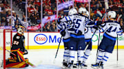 Oct 26, 2024; Calgary, Alberta, CAN; Winnipeg Jets left wing Nikolaj Ehlers (27) celebrates his goal with teammates against Calgary Flames goaltender Dustin Wolf (32) during the first period at Scotiabank Saddledome. Mandatory Credit: Sergei Belski-Imagn Images
