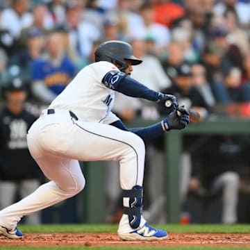 May 12, 2025; Seattle, Washington, USA; Seattle Mariners right fielder Leody Taveras (4) bunts the ball during the second inning against the New York Yankees at T-Mobile Park. Mandatory Credit: Steven Bisig-Imagn Images