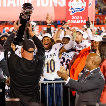 Dec 19, 2023; Frisco, TX, USA; UTSA Roadrunners head coach Jeff Traylor holds the trophy towards his players after winning the Frisco Bowl against the Marshall Thundering Herd at Toyota Stadium. Mandatory Credit: Andrew Dieb-USA TODAY Sports