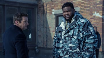 L-R: Jeremy Renner as Mike McLusky and Tobi Bamtefa as Deverin "Bunny" Washington in Mayor of Kingstown episode 1, season 4, streaming on Paramount+, 2025. Credit: Dennis P. Mong Jr./Paramount+