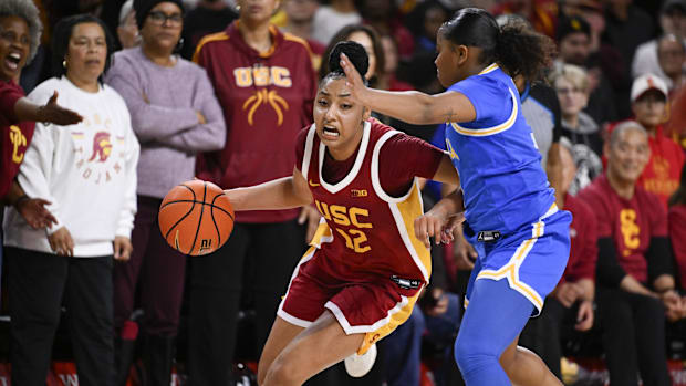 Feb 13, 2025; Los Angeles, California, USA; USC Trojans guard JuJu Watkins (12) dribbles against UCLA Bruins guard Londynn Jo