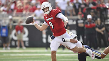 Sep 21, 2024; Louisville, Kentucky, USA;  Louisville Cardinals quarterback Tyler Shough (9) looks to pass while being tackled by Georgia Tech Yellow Jackets linebacker Kyle Efford (44) during the first quarter at L&N Federal Credit Union Stadium. Mandatory Credit: Jamie Rhodes-Imagn Images
