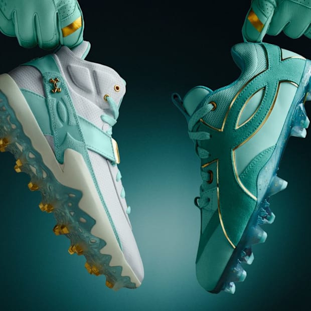 White and teal Under Armour baseball cleats.