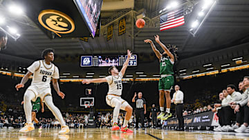 Nov 20, 2025; Iowa City, Iowa, USA; Chicago State Cougars guard Braelon Bush (21) shoots the ball as Iowa Hawkeyes guard Brendan Hausen (15) and guard Tavion Banks (6) defend during the first half at Carver-Hawkeye Arena. Mandatory Credit: Jeffrey Becker-Imagn Images