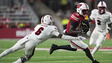 Aug 28, 2025; Madison, Wisconsin, USA;  Wisconsin Badgers wide receiver Eugene Hilton Jr. (13) rushes with the football against Miami (OH) RedHawks defensive back Adrian Walker Jr. (6) during the third quarter at Camp Randall Stadium. Mandatory Credit: Jeff Hanisch-Imagn Images