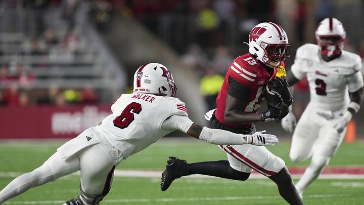 Aug 28, 2025; Madison, Wisconsin, USA;  Wisconsin Badgers wide receiver Eugene Hilton Jr. (13) rushes with the football against Miami (OH) RedHawks defensive back Adrian Walker Jr. (6) during the third quarter at Camp Randall Stadium. Mandatory Credit: Jeff Hanisch-Imagn Images