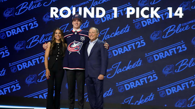 Jackson Smith poses for photos after the Columbus Blue Jackets selected him in the first round of the 2025 NHL Draft.